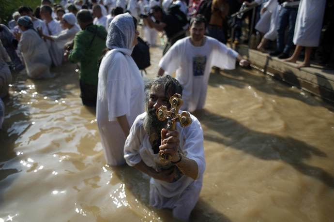 Un pèlerin chrétien tient une croix alors qu’il se penche dans l’eau après une cérémonie au site baptismal connu sous le nom de Qasr el-Yahud, sur les rives du fleuve Jourdain près de la ville cis-jordanienne de Jéricho, le 18 janvier 2015 Photo Reuters / Mohamad Torokman